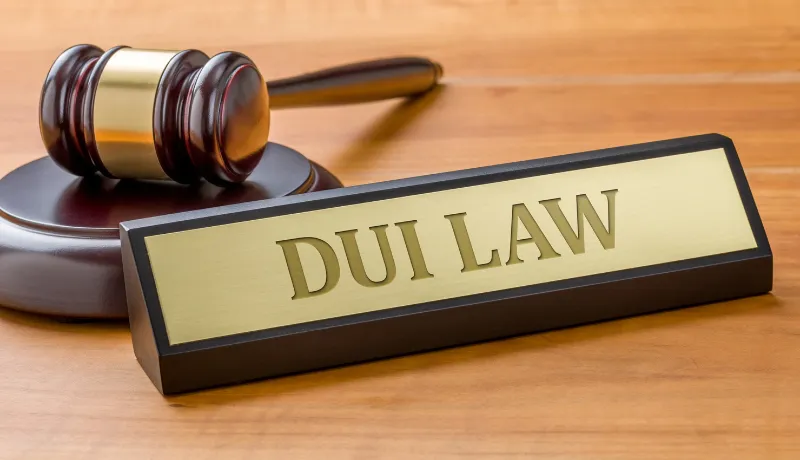 A gavel and a name plate with the engraving DUI Law