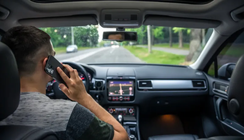 Businessman talking on cell phone while driving.