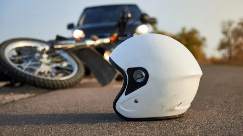 Photo of car, helmet and motorcycle on road, the concept of road accidents.