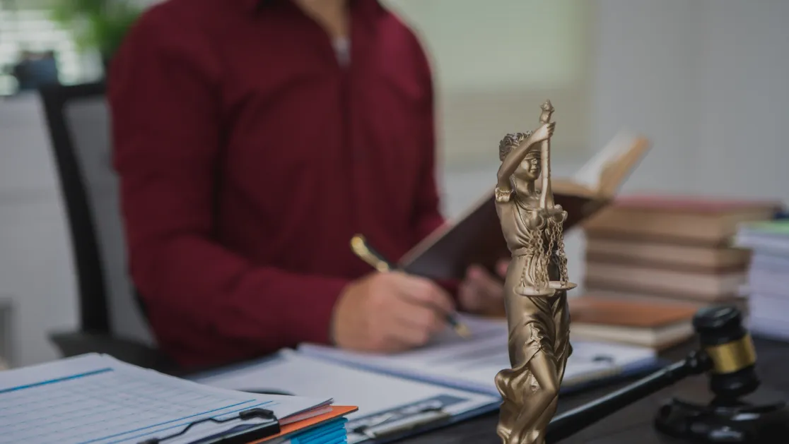 An Asian male lawyer meticulously reviews legal documents, ensuring accuracy and compliance for an upcoming court case.
