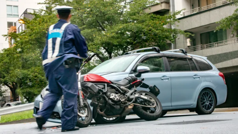 Car and motorcycle collision scene and police officers