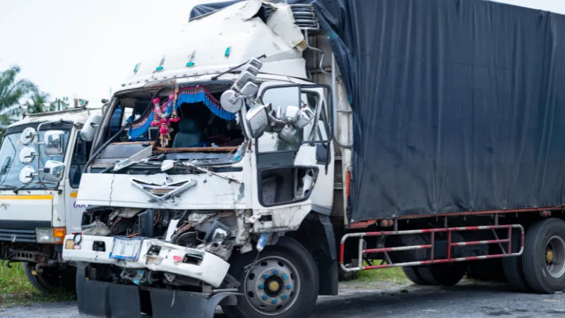 Damaged truck involved in road accident with severe front-end impact, showing collision damage and safety concerns,