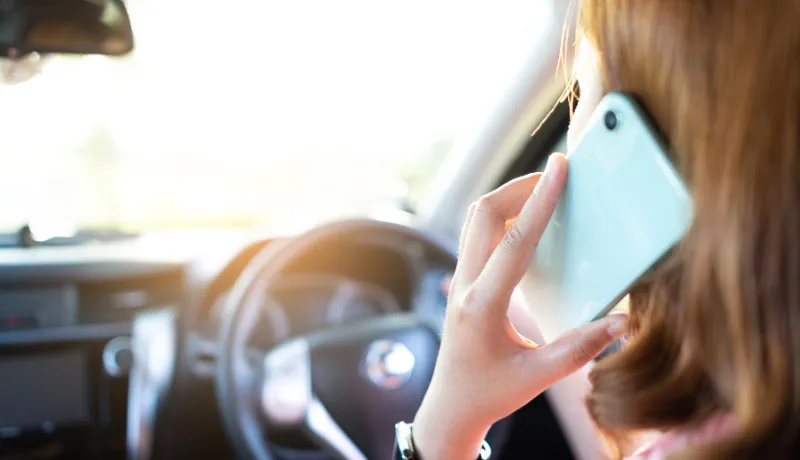 woman talking on the phone on her car
