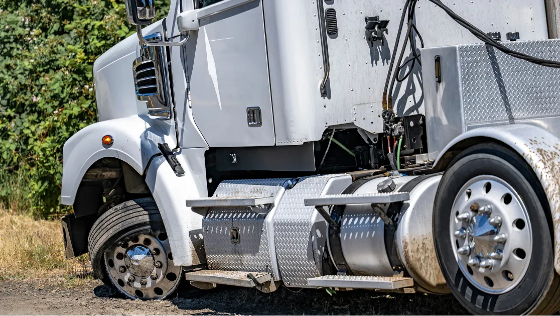 A white truck is pulled over on the side of the road.
