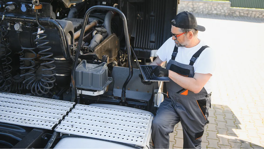 A car technician using a laptop to diagnose the truck’s issue.